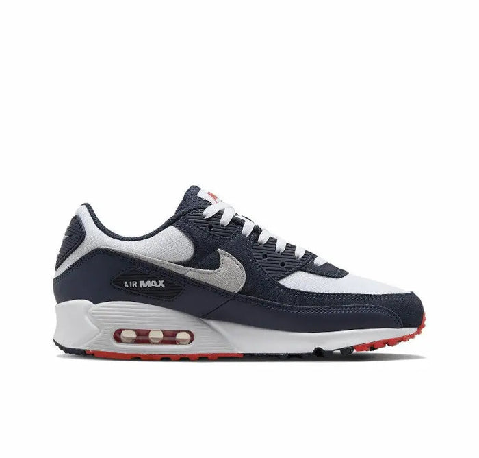Nike Air Max 90 side profile with navy upper, grey swoosh, white midsole, red Air window