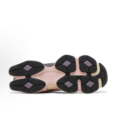 New Balance 9060 sneaker outsole with dark traction pods and pink midsole trim.