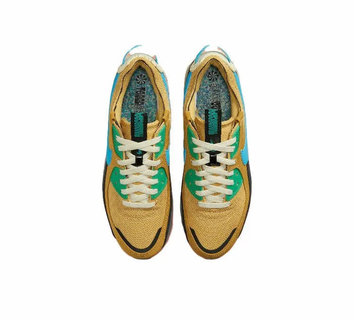 Nike Air Max 90 shoe in wheat gold with white laces, teal lining, and blue-green accents